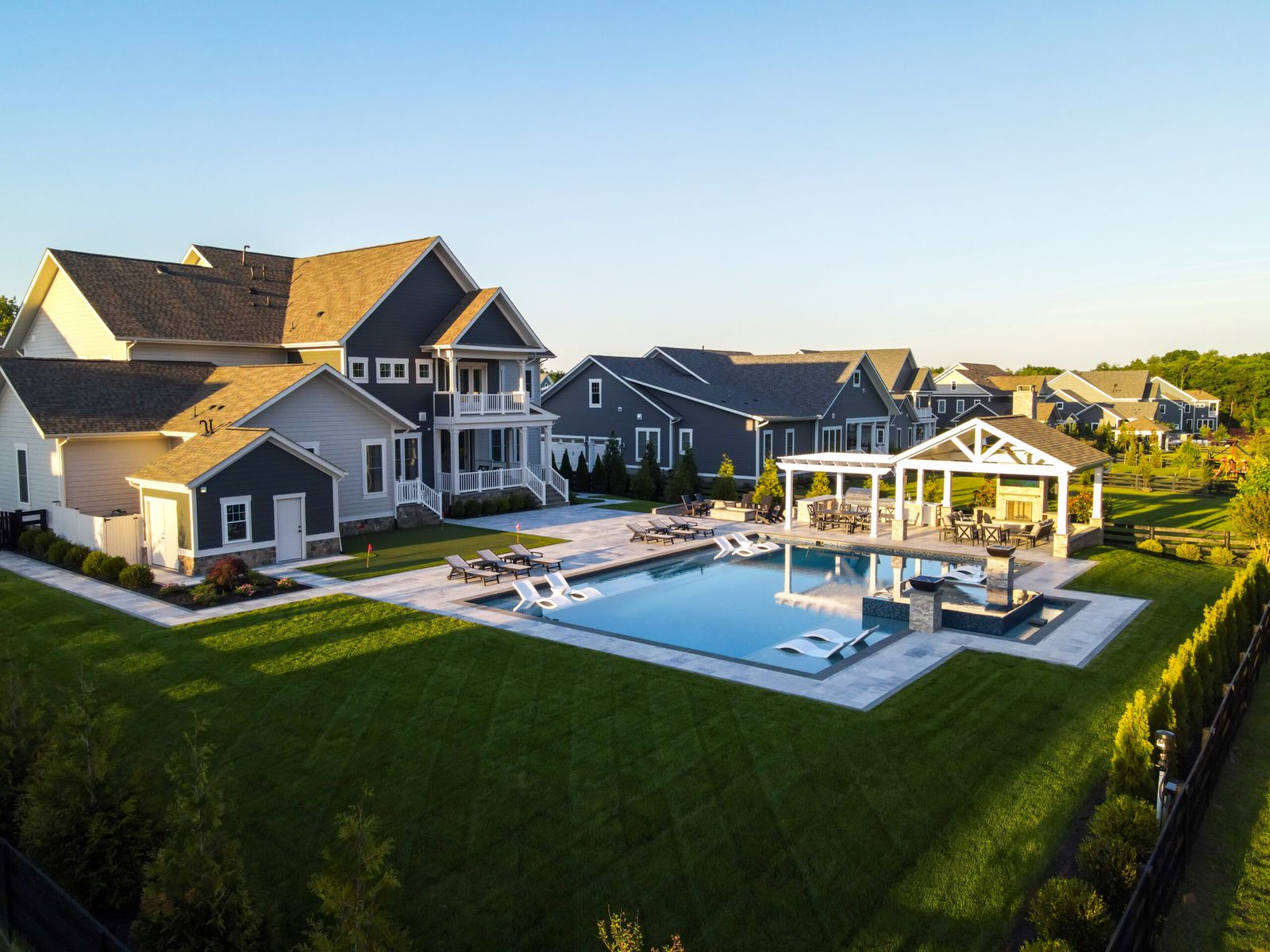 Complete backyard project by Outdoor Solutions: fiberglass pool, spa, pavilion, pergola, and putting green in a Northern Virginia neighborhood